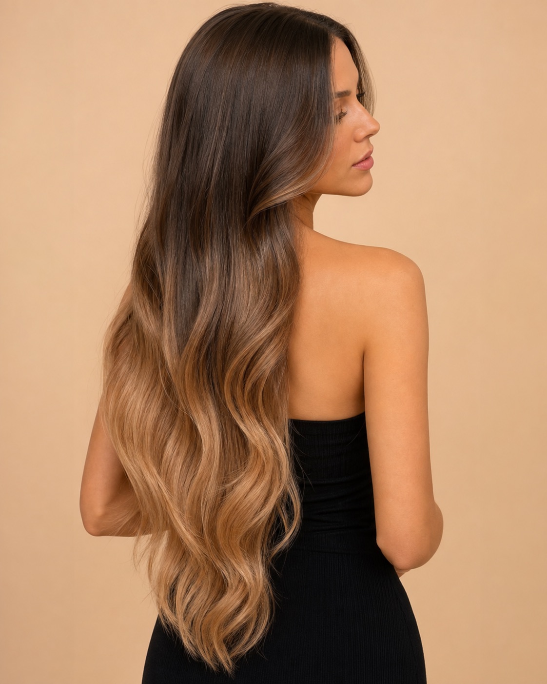 Long ombre hair transitioning from brunette roots to caramel-blonde ends